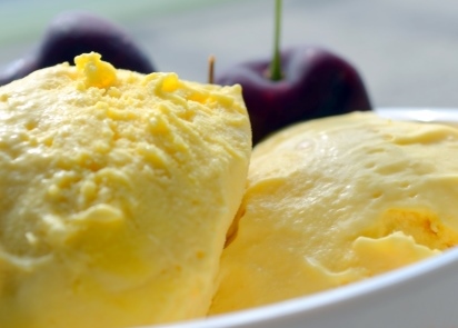 Home-made mango ice-cream with black cherries