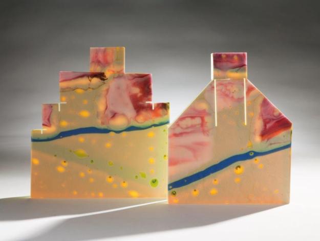 (Two small houses) Judi Elliott. On our Street 1.  Height 19cm x 19cm. Cast cut and assembled glass. On our street 2, Height 19cm x 15cm. Cast, cut and assembled glass. Image credit: Rob Little.